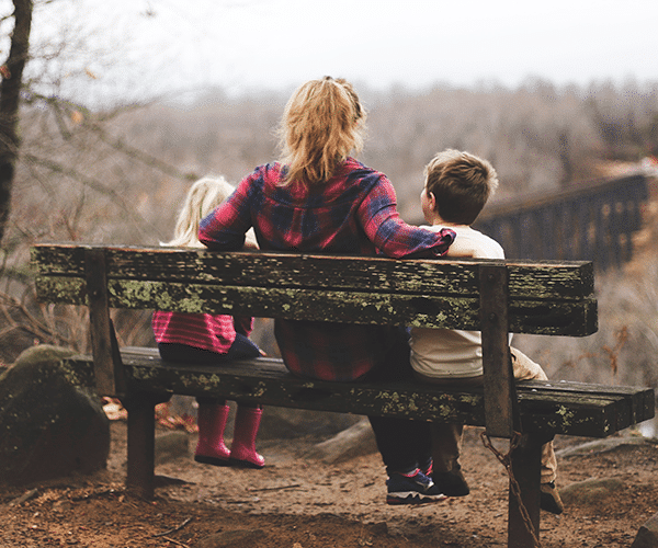 Woman and two children in woods crop